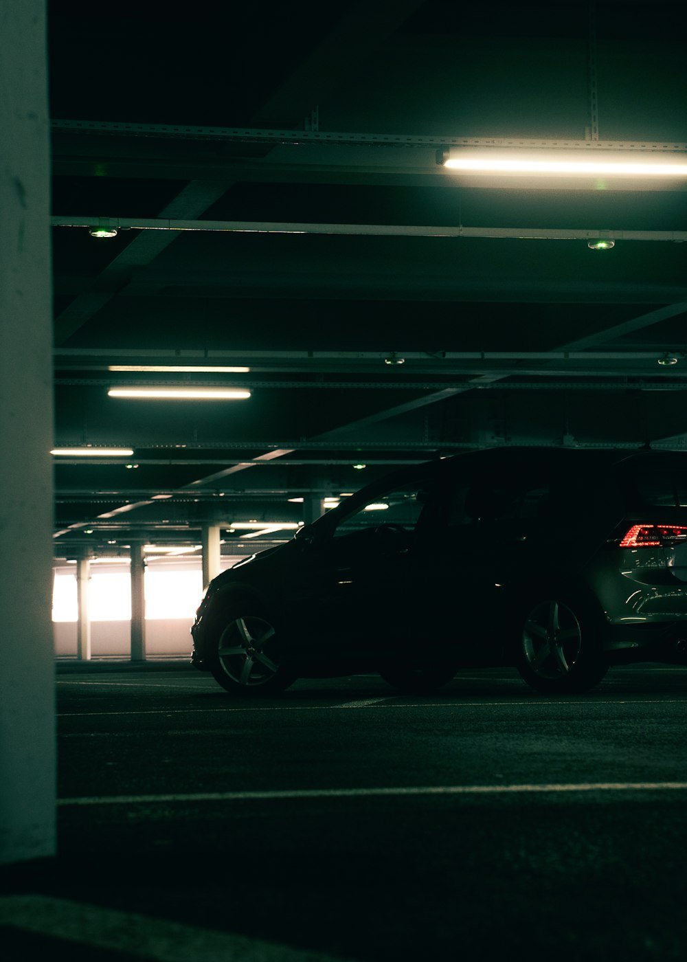 Demo image: black Volkswagen hatchback in a vertically framed garage view