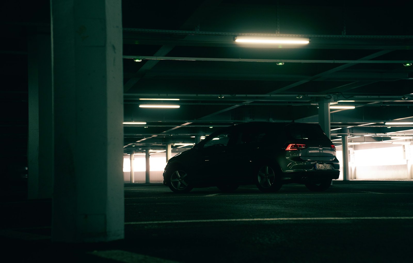 Demo image: black Volkswagen hatchback parked in a covered garage